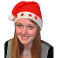Bonnet de Noël rouge porté, avec bord blanc, pompon et étoiles rouges lumineuses.