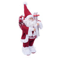 Père Noël décoratif en tenue rouge et blanche, portant des skis et un sac.